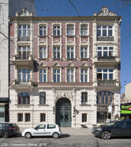 Fassade und Vestibül eines Mietshauses mit Laden